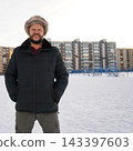 Front view of an angry aggressive bearded man growling on snow outdoors wearing warm winter fur hat. 143397603