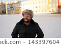 Portrait of a suspicious mature man looking aside with disbelief at winter snowy street. 143397604