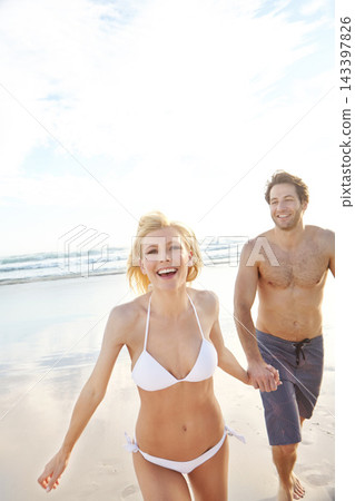 Holding hands, walking and portrait of couple on beach for travel, vacation or holiday with romance together. Happy, summer and young man and woman by ocean for bonding on weekend trip in Australia. Holding hands, walking and portrait of couple on beach for travel, vacation or holiday with romance together. Happy, summer and young man and woman by ocean for bonding on weekend trip in Australia. 143397826