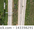 Top down drone aerial view of divided highway with road markings and sugarcane plantation 143398291