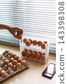 Hand Selecting Fresh Chicken Eggs from Egg Cartons 143398308