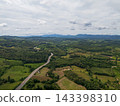 Aerial drone view of Highway winding through lush green mountains between Nan, Thailand. A scenic landscape of the road surrounded by tropical forest and a peaceful countryside 143398310
