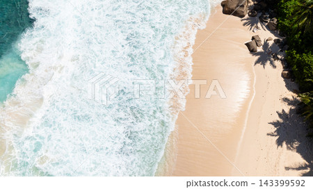 Waves crashing on the sandy coastline with palm shadows on the shore. Seychelles, Mahe. Waves crashing on the sandy coastline with palm shadows on the shore. Seychelles, Mahe. 143399592