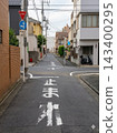 日本住宅區道路上褪色的「停止」字樣和標誌。 143400295