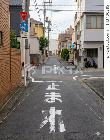 Faded "STOP" lettering and signs painted on the roads of residential areas in Japan. 143400295