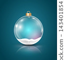 Transparent Christmas ball with snow at the bottom and colorful glow inside on a dark teal background. 143401854
