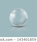 Transparent glass sphere with soft highlights on a glossy light blue surface. 143401859