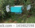 blue bucket hanging on a wall, hanging from a hose 143402598