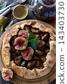 Fresh fig galette with mint leaves on wooden serving board 143403730