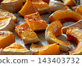 Roasted pumpkin slices on a baking tray with golden brown edges. 143403732