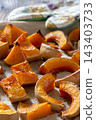 Roasted pumpkin slices on baking sheet with colorful kitchen towel. 143403733