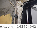 Close-Up of Foam Insulation Application in Construction Setting with Visible Pipe Leakage and Framing 143404042