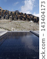 Solar panels lying on ground with vertically mounted four wings around central column, photovoltaic plant avoid snow accumulation, maintain high yields, Alps, future innovation energy concept 143404173