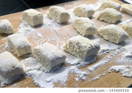 Homemade Gnocchi Preparation on a Floured Wooden Surface for Culinary Delight 143404350