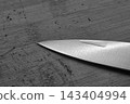 Sharp Knife Blade on Wooden Surface - Precision and Craftsmanship in Kitchen Tools 143404994