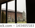 Rainy view through window frame of brick house and trees 143405583