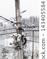 Snow covered utility pole with tangled wires and forest background 143405584