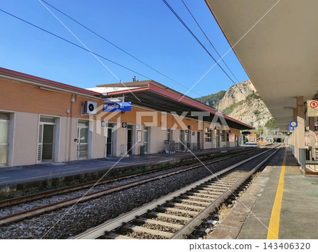 Railway station of Finale Ligure Marina (Ligurian Coast) with mountains in the background. Finale Ligure is beautiful seaside town and popular resort on Ligurian Riviera in Italy Railway station of Finale Ligure Marina (Ligurian Coast) with mountains in the background. Finale Ligure is beautiful seaside town and popular resort on Ligurian Riviera in Italy 143406320