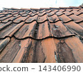 Fragment of an old tiled roof beneath the clouds 143406990