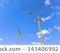 High-rise tower cranes against a blue sky 143406992