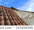 Old tiled roof with a textured wall 143406996