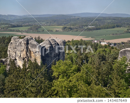 Cliff edges painted. Eroded cliff with foliage on rim overlooks patchwork farmland and faroff lush valley Cliff edges painted. Eroded cliff with foliage on rim overlooks patchwork farmland and faroff lush valley 143407649