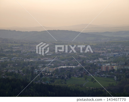 Urban landscape under evening haze. Overview of sprawling metropolis and surrounding green areas Urban landscape under evening haze. Overview of sprawling metropolis and surrounding green areas 143407770