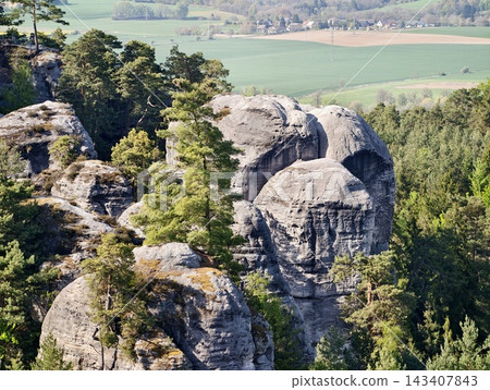 Majestic twin cliffs. Tall twin rock formations with moss and layered textures stand prominently Majestic twin cliffs. Tall twin rock formations with moss and layered textures stand prominently 143407843