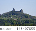 Majestic ancient castle wreckage crowns hilltop overlooking forests and charming village below 143407855