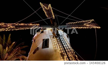A illuminated windmill at night with decorative lights adds charm to the evening A illuminated windmill at night with decorative lights adds charm to the evening 143408126