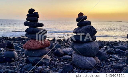 The Tranquil and Serene Stone Balanced Towers Stand Majestically at Sunset by the Shoreline The Tranquil and Serene Stone Balanced Towers Stand Majestically at Sunset by the Shoreline 143408131