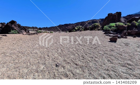 A desolate landscape characterized by rocky terrain and a vast, bright blue sky above it A desolate landscape characterized by rocky terrain and a vast, bright blue sky above it 143408209