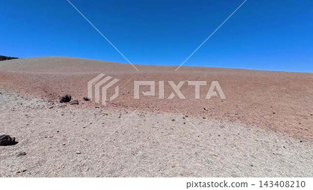 A Barren and Desolate Landscape Featuring Rocks Set Against a Clear and Bright Blue Sky 143408210