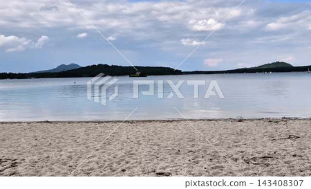A Serene Beach Landscape Capturing the Tranquil Waters and Scenic Islands Nearby A Serene Beach Landscape Capturing the Tranquil Waters and Scenic Islands Nearby 143408307