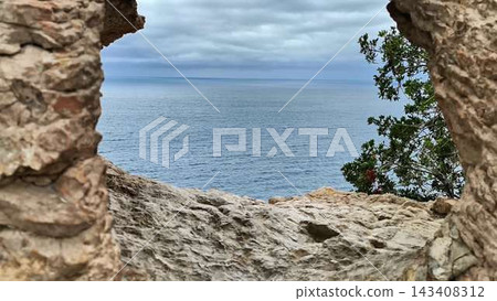 A Beautiful Scenic View Through a Stunning Rocky Arch Overlooking the Ocean Waves A Beautiful Scenic View Through a Stunning Rocky Arch Overlooking the Ocean Waves 143408312