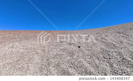 A Barren Landscape Set Against a Clear Blue Sky, Depicting a Serene Wilderness Scene A Barren Landscape Set Against a Clear Blue Sky, Depicting a Serene Wilderness Scene 143408347