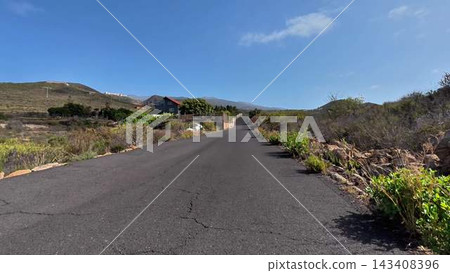 A picturesque scenic roadway in nature under a beautifully clear blue sky with few clouds A picturesque scenic roadway in nature under a beautifully clear blue sky with few clouds 143408396
