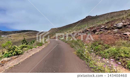 A beautiful and scenic mountain road adorned with lush greenery and vibrant terrain all around A beautiful and scenic mountain road adorned with lush greenery and vibrant terrain all around 143408468