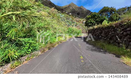A Scenic and Beautiful Winding Mountain Road is Surrounded by Lush, Vibrant Greens A Scenic and Beautiful Winding Mountain Road is Surrounded by Lush, Vibrant Greens 143408489