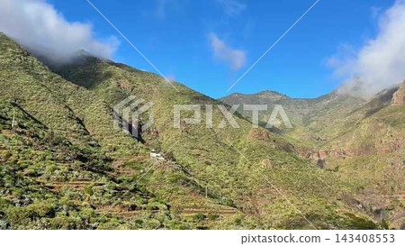 The stunning mountain features lush greenery and beautiful blue skies, inviting exploration The stunning mountain features lush greenery and beautiful blue skies, inviting exploration 143408553