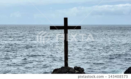 A Stunning Cross Overlooking Ocean Waves at Glorious Sunset, A True Sight to Behold A Stunning Cross Overlooking Ocean Waves at Glorious Sunset, A True Sight to Behold 143408573