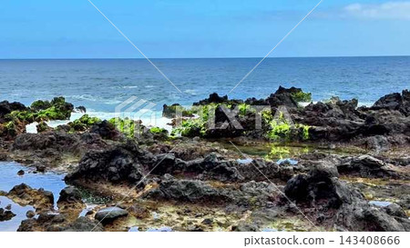 A Serene and Beautiful Coastal Landscape featuring a Rocky Shoreline alongside Clear Blue Waters A Serene and Beautiful Coastal Landscape featuring a Rocky Shoreline alongside Clear Blue Waters 143408666