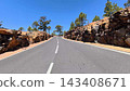A Beautiful Scenic Road That is Surrounded by Lush Trees and Majestic Rock Formations 143408671