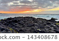 A Stunning Sunset Over the Rocky Shoreline Accompanied by Gentle Ocean Waves Creating Beauty 143408678