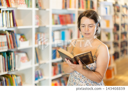 In bookstore woman choose book In bookstore woman choose book 143408839
