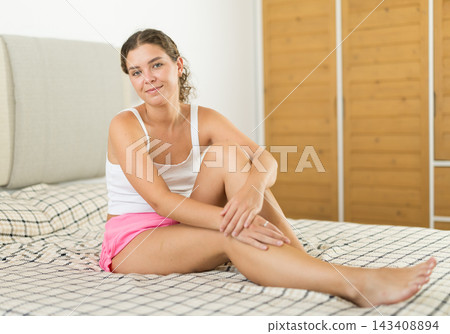 Young woman posing on bed in bedroom Young woman posing on bed in bedroom 143408894