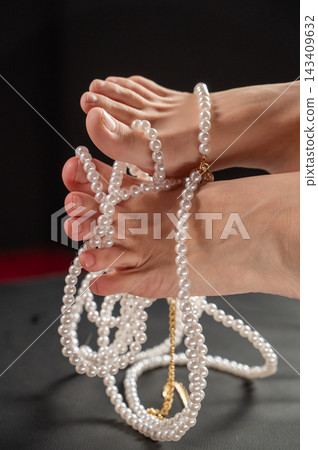 Foot fetish. Bare female feet with pearl beads. Foot fetish. Bare female feet with pearl beads. 143409632