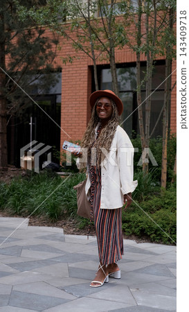 Smiling Young Woman with Smartphone in Stylish City Outfit, Urban Street Fashion, Positive Lifestyle, Confidence and Modern Femininity Smiling Young Woman with Smartphone in Stylish City Outfit, Urban Street Fashion, Positive Lifestyle, Confidence and Modern Femininity 143409718