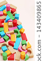 Colorful Wooden and Plastic Toy Building Blocks on Pastel Pink Background with Copy Space 143409865