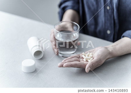 一位女士正在服用大量藥物,她的雙手。 一位女士正在服用大量藥物,她的雙手。 143410893
